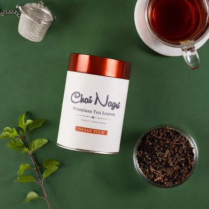 Tulsi Tee mit losem Kräutertee, frischen Tulsi Blättern und einer Tasse frisch gebrühtem Tee